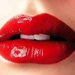 真っ赤な口紅をする唇の画像